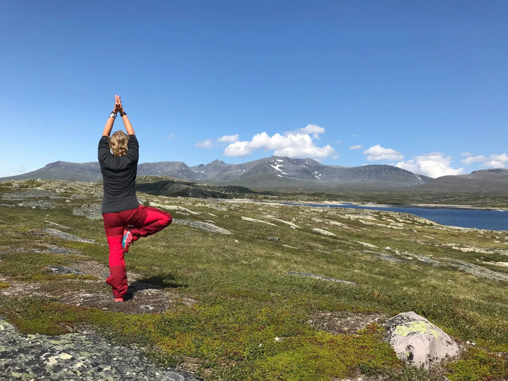 Person som står i yogaposition på fjället