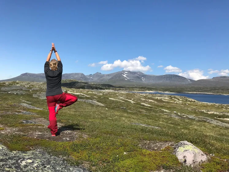 Person som står i yogaposition på fjället