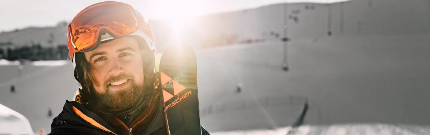 Man står med alpinskidor
