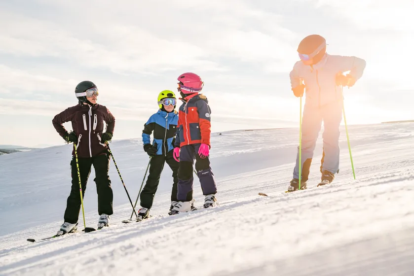 Familj åker utförsåkning på fjället