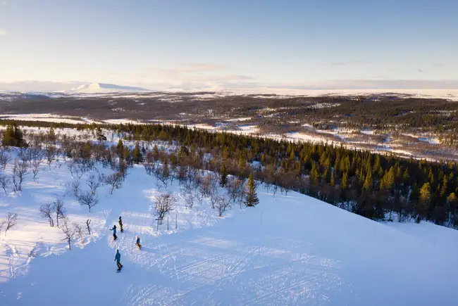 Familj åker skidor nedför pist i Kappruet
