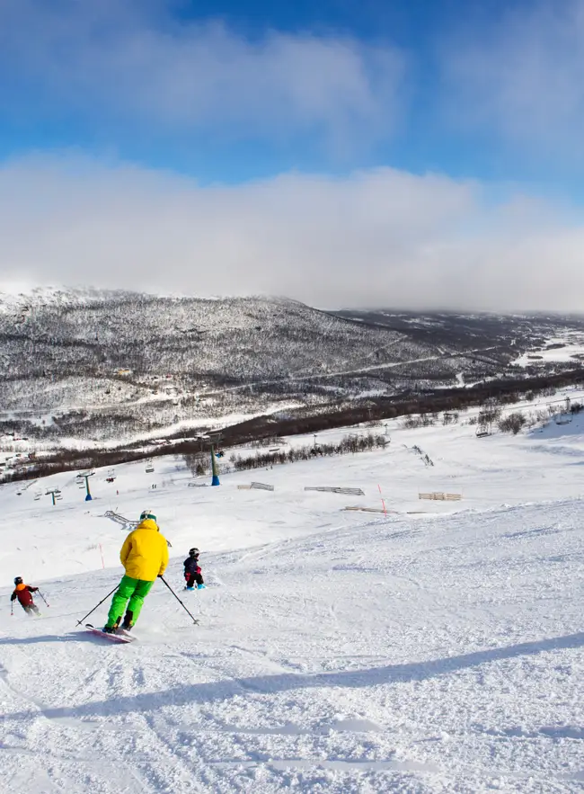 Familj åker skidor i en pist i Tänndalen