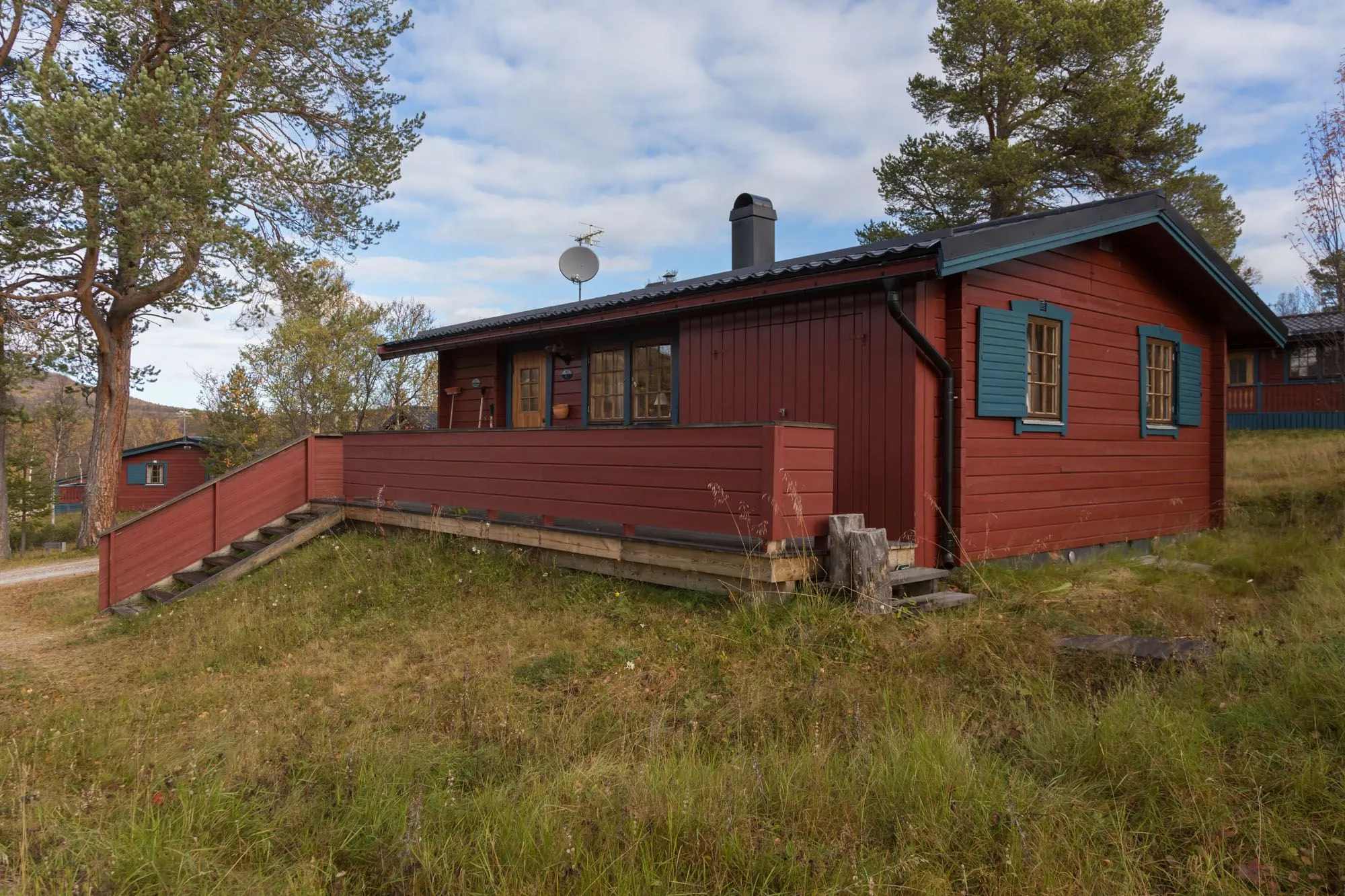 Röd stuga i fjällmiljö