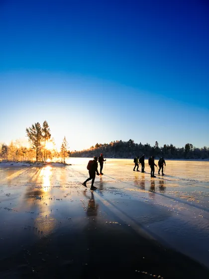 Personer åker Långfärdskridskor på en sjö i Funäsdalen