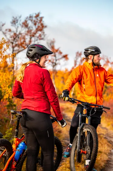 Två personer cyklar mtb i höstfärger