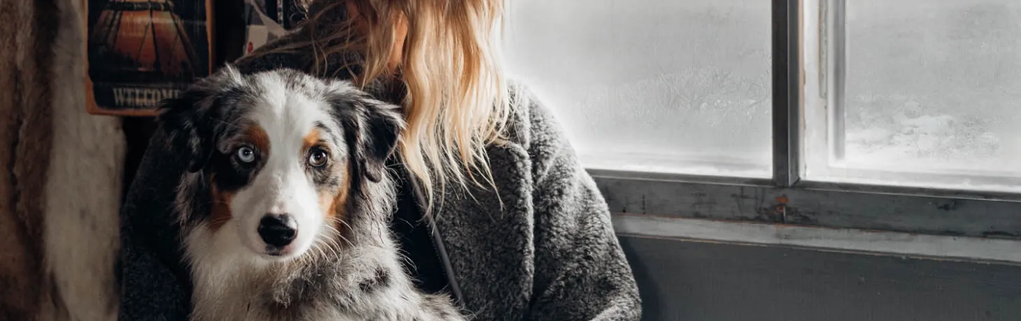 Kvinna myser med sin hund i en fjällstuga