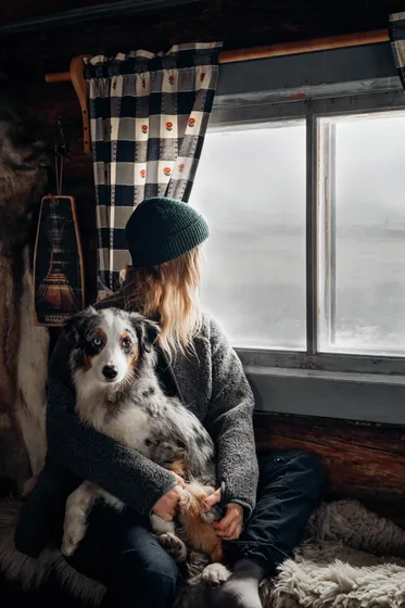 Kvinna myser med sin hund i fjällen