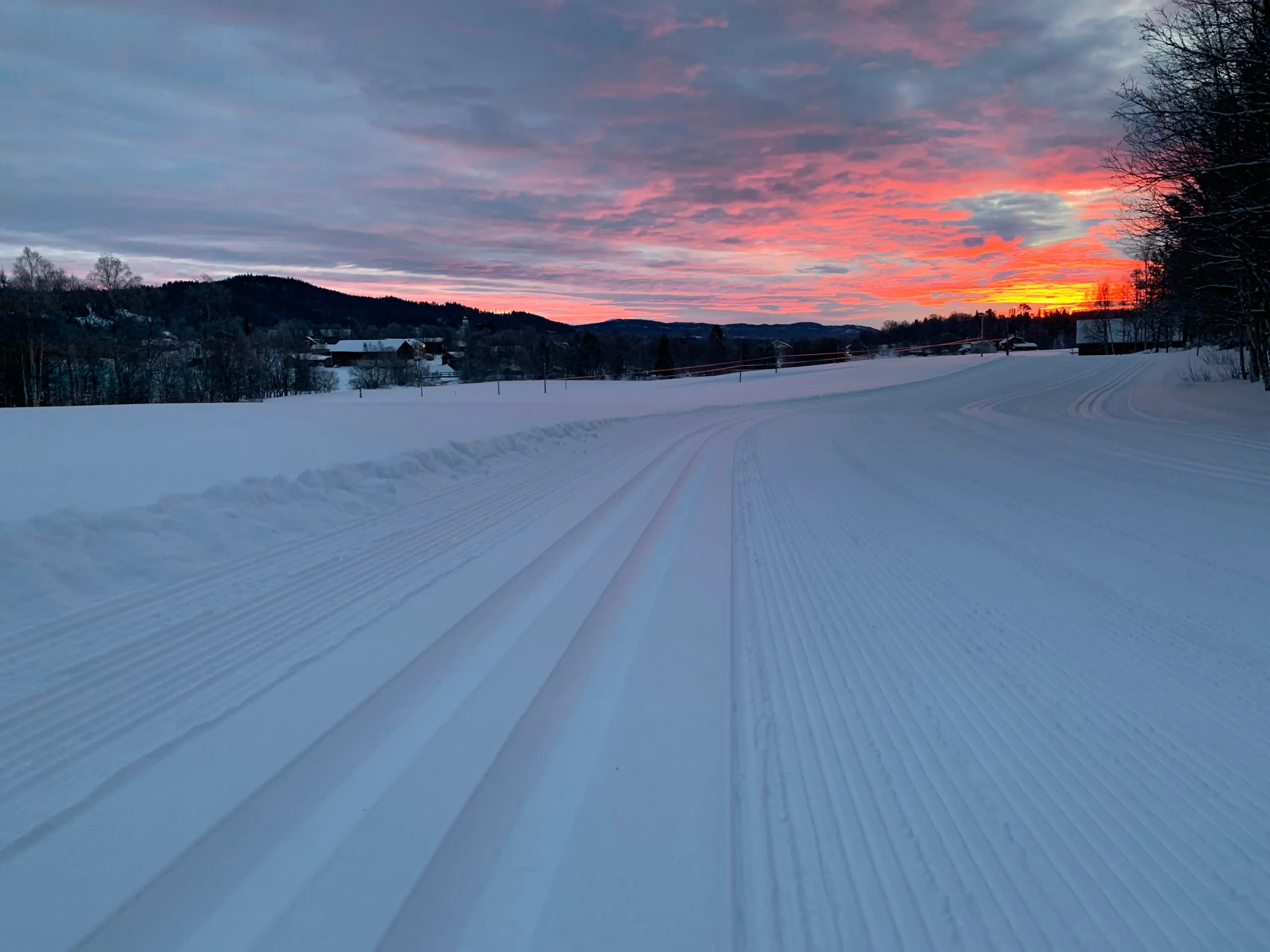 Tidig morgon med soluppgång över skidspår.