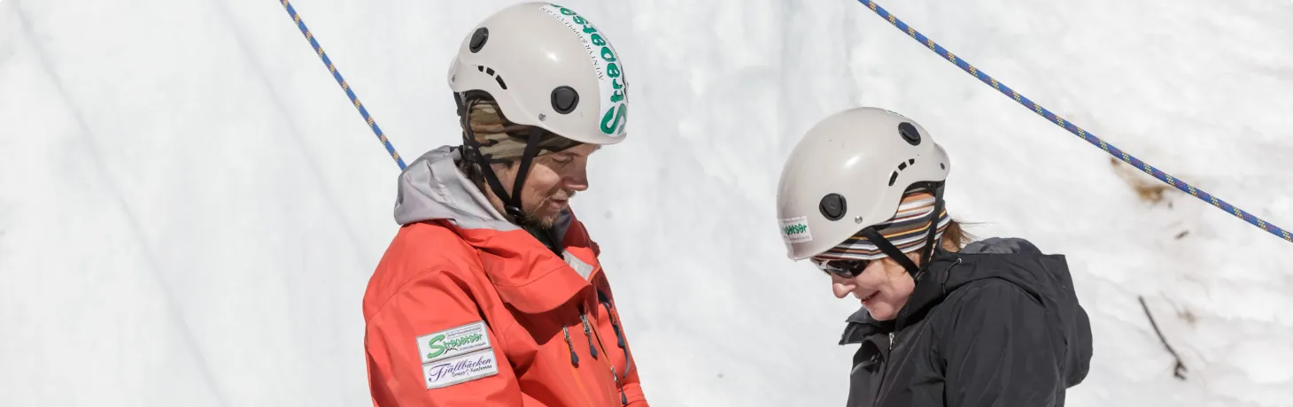 Guide hjälper en person under isklättring
