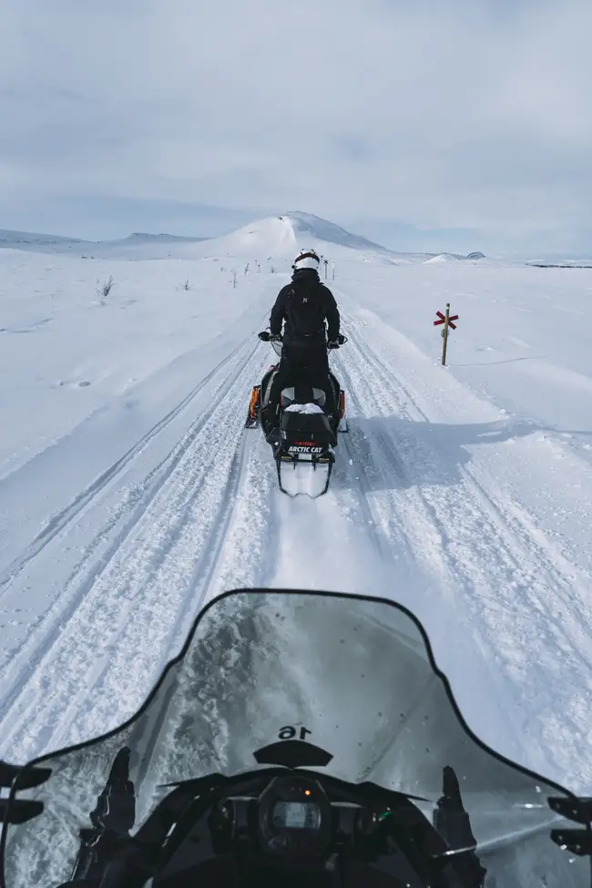 Person åker skoter på fjället