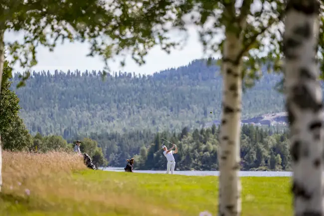 En person gör en swing med en golfklubba